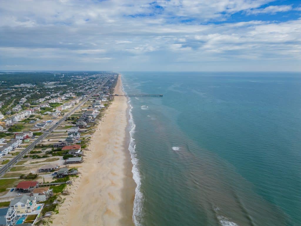 View from above with drone on Outer Banks Coast with pier in the distance