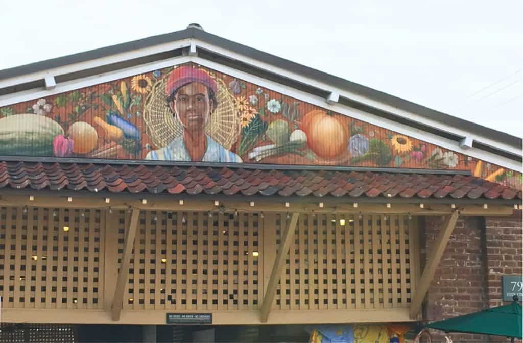 Mural on top of the Charleston City Market with a woman and different flowers, basket, vegetables