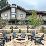 Outdoor seating area at Beech Mountain Resort Village with Adirondack chairs and a fire pit surrounded by landscaped terraces.
