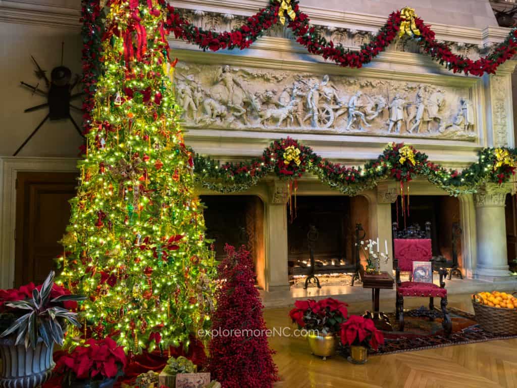 The grand Christmas tree at the Biltmore Estateβs main hall, surrounded by lush poinsettias, garlands, and festive decorations.