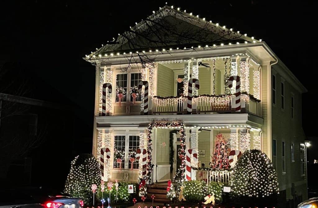 A beautifully decorated house with candy cane columns and twinkling Christmas lights in McAdenville, NC, also known as Christmas Town USA.
