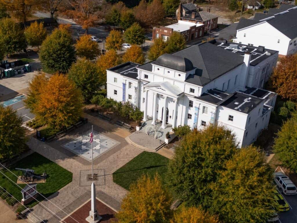 Historic building Wilkes Heritage Museum surrounded by autumn trees.