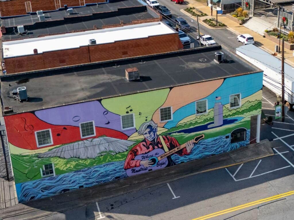 Colorful mural of Doc Watson depicting music and nature.